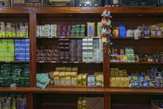 An assortment of different tea products on wooden shelves in a shop, tea cultivation and production