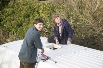 Cutting through roof of white metal camper van conversion to install ventilation window, UK