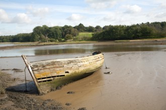 Old abandoned boat on River Deben at low tide, Melton, Suffolk, England, UK