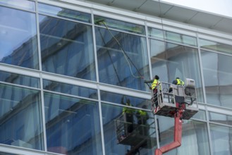 Window cleaner, building maintenance, facade cleaning, on a cherry picker, in Düsseldorf, North