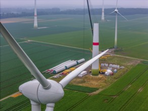 Erection of the tower of a wind power plant in a wind farm near Issum, 9 older wind turbines from