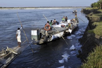 Public Works Department (PWD) of Assam labourer throwing sand bag from boat in the banks of Beki