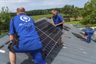 Installation of solar modules on the roof of a barn on a farm, over 240 photovoltaic modules are