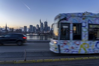 Skyline of the city centre of Frankfurt am Main, tram on the Ignatz-Bubis-Bridge, dusk, river Main,