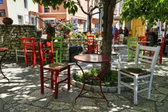 Terrace under trees, colourful chairs and tables in front of a café, small town Leonidi, Leonidio,