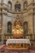 Artistic baroque altar in a church with candles and religious motifs, Granada