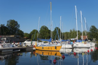 Sailing boats in the harbour with red buoys and a clear blue sky in summer, Gizycko,