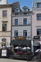 Cosy restaurant in a historic building with a decorative façade and parasols in the city centre,