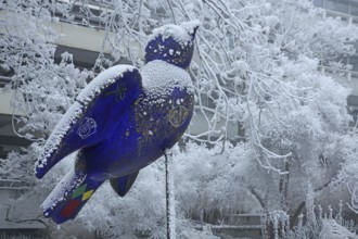 Blue Ulm sparrow with hoarfrost, ice and snow in winter, iced, sculpture, landmark, bird figure,