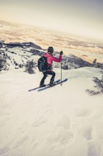 A woman's ski tour at sunrise on the Tegelberg in the Allgäu in the Ammergebirge, Bavaria, Germany,