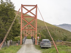 Traditional orange suspension bridge below waterfall Mellizo south of Cochrane, weight limit 1.5 t,