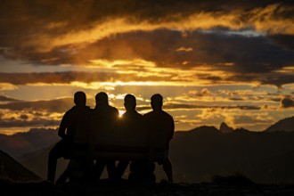 People marvelling at Montafon mountains with dramatic cloudy sky at sunset, Tschagguns, Rätikon,