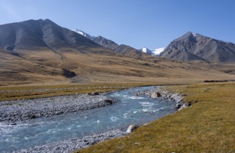 Blue river in the Burkhan valley, mountain landscape with glaciated peaks and golden meadows,