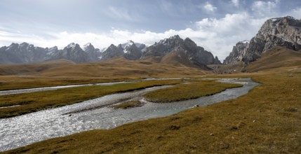 Kol Suu River between autumnal yellow meadows with mountain panorama of the Keltan Mountains, Sary