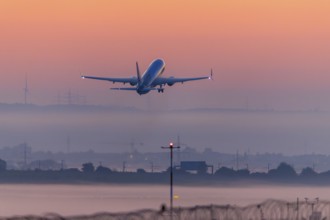 Passenger aircraft after take-off, in front of sunrise, fog, Baden-Württemberg, Germany, Europe