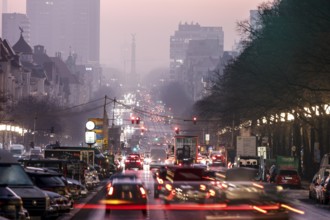 Busy Kaiserdamm and Bismarckstraße during morning rush hour in foggy and cloudy winter weather,