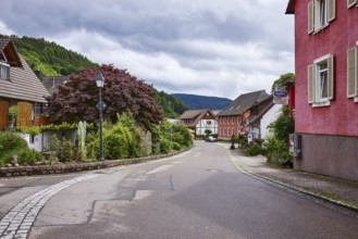 Multi-family houses, lantern, hilly landscape with forest, tavern Am Dorfbach, overcast sky with