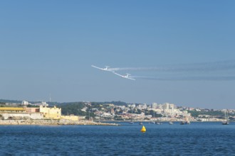 Stunt aerobatic plane performing stunts in blue sky with smoke trail. Concept of teamwork,