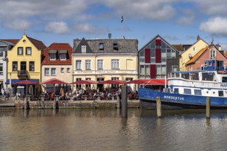 The MS Nordertor restaurant ship in the inland harbour and the old town in Husum, North Friesland