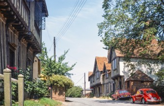 Historische Fachwerkhäuser roter VW-Käfer Volkswagen Auto auf der Straße, Stoke by Nayland,