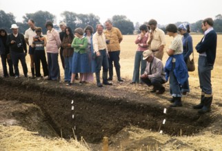 People looking at a trench at the University of Cambridge archaeological site called Great