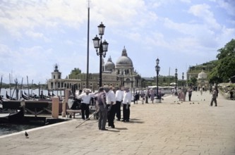 Gondoliers and gondolas, Riva degli Schiavoni, Basilica Santa Maria della Salute, Venice, Italy,