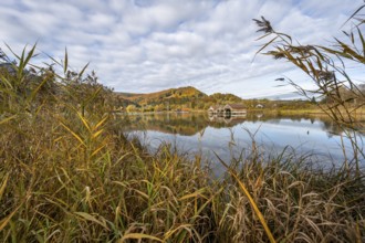 Autumn landscape on the shore of Lake Lake Kochel, boat huts in the lake, autumn mountain landscape