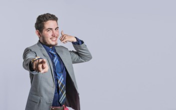 Man making phone gesture with his fingers, Hispanic young man making phone gesture and pointing to