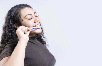 Face of young woman brushing teeth isolated. Oral and dental smile concept. Smiling woman brushing