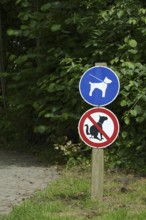 Signs 'Dog excrement prohibited' and 'Dogs on a lead' in a park, North Rhine-Westphalia, Germany,