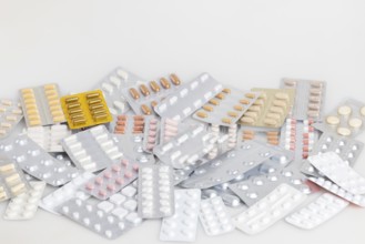 A collection of different medicines in blister packs on a light-coloured background