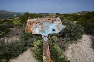 An old, rusty tank lies on a dry, grassy landscape, Anthony Quinn Bay, Vagies Bay, Rhodes,