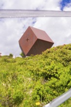 A modern metal chapel sits on a green hill under a cloudy sky, Penken, Zillertal, Austria, Europe