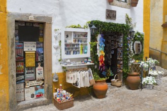 Small shop in a cobbled alley offering souvenirs and colourful handicrafts, R. Direita, Óbidos,