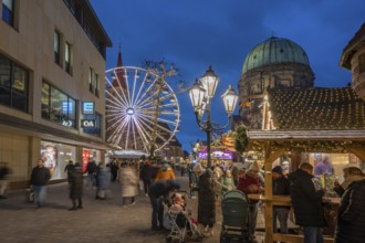 Ferris wheel at the winter village, Christmas market at dusk, St James' Church on the left, St