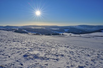 Hilly, snow-covered landscape under bright sun and blue sky, winter, Wasserkuppe, Gersfeld, Rhön,