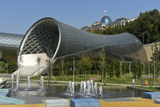 Futuristic theatre building and exhibition hall in Rike City Park, architect Studio Fuksas, behind