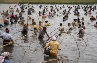 Villagers participate in a community fishing event on the occasion of the Bhogali Bihu festival at