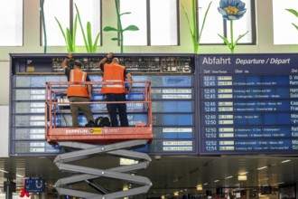 Technicians working on an electronic information board, display board for train connections at