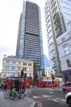 Skyscrapers and red double-decker buses in a busy street scene in the city of London, United