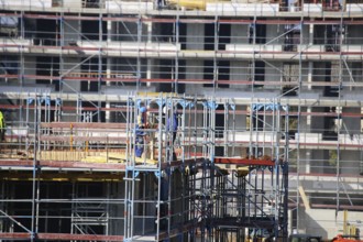 Photo of a large construction site in a newly developed residential area. Several apartment