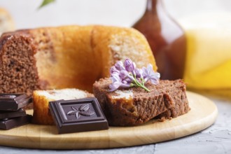 Cakes with raisins and chocolate and a cup of coffee. lilac flowers on a gray concrete background,