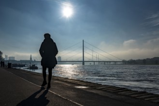 Dense fog is slowly lifting, riverside promenade on the Rhine near Düsseldorf, in front the