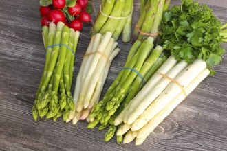 Green asparagus and white asparagus decorated on a rustic wooden table