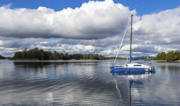 Yacht on Galve lake, Lithuania with blue cloud sky on the background