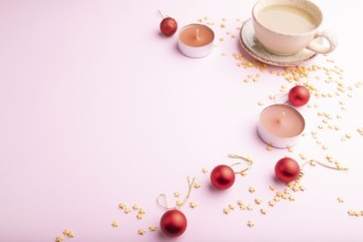 Christmas or New Year composition. Decorations, red balls, cup of coffee, on a pink paper