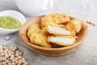 Traditional indian food paneer pakora in wooden plate with mint chutney on a gray concrete