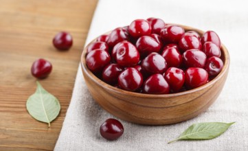 Fresh red sweet cherry in wooden bowl on wooden background. side view, close up