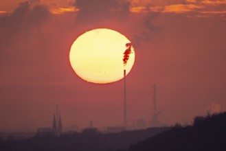 Setting sun in front of the industrial skyline of Duisburg, North Rhine-Westphalia, Germany, Europe