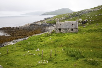 Deserted derelict croft cottage in coastal location on Vatersay Island, Barra, Outer Hebrides,